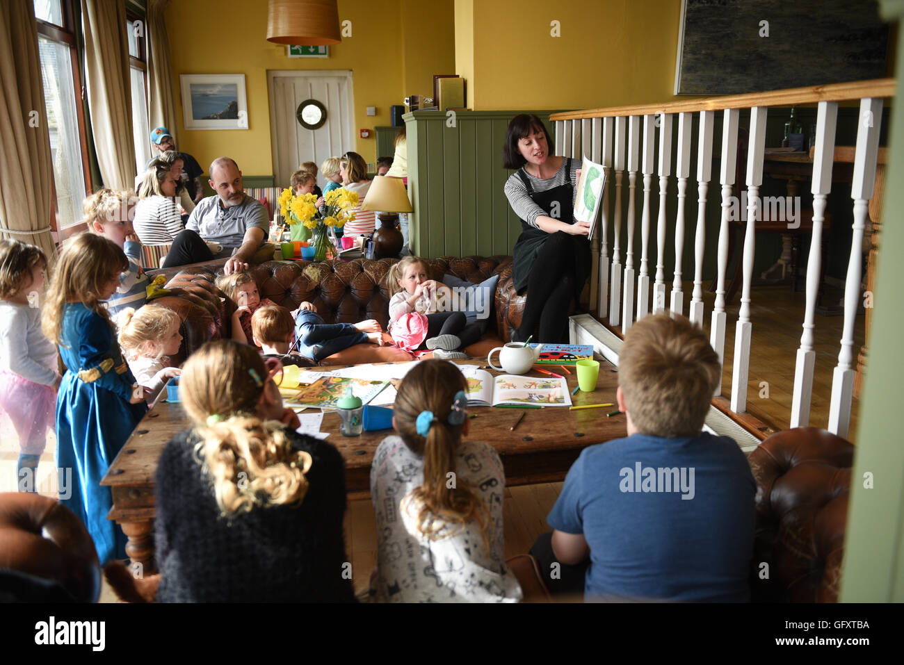 woman storytelling to children at a pub in Cornwall Stock Photo