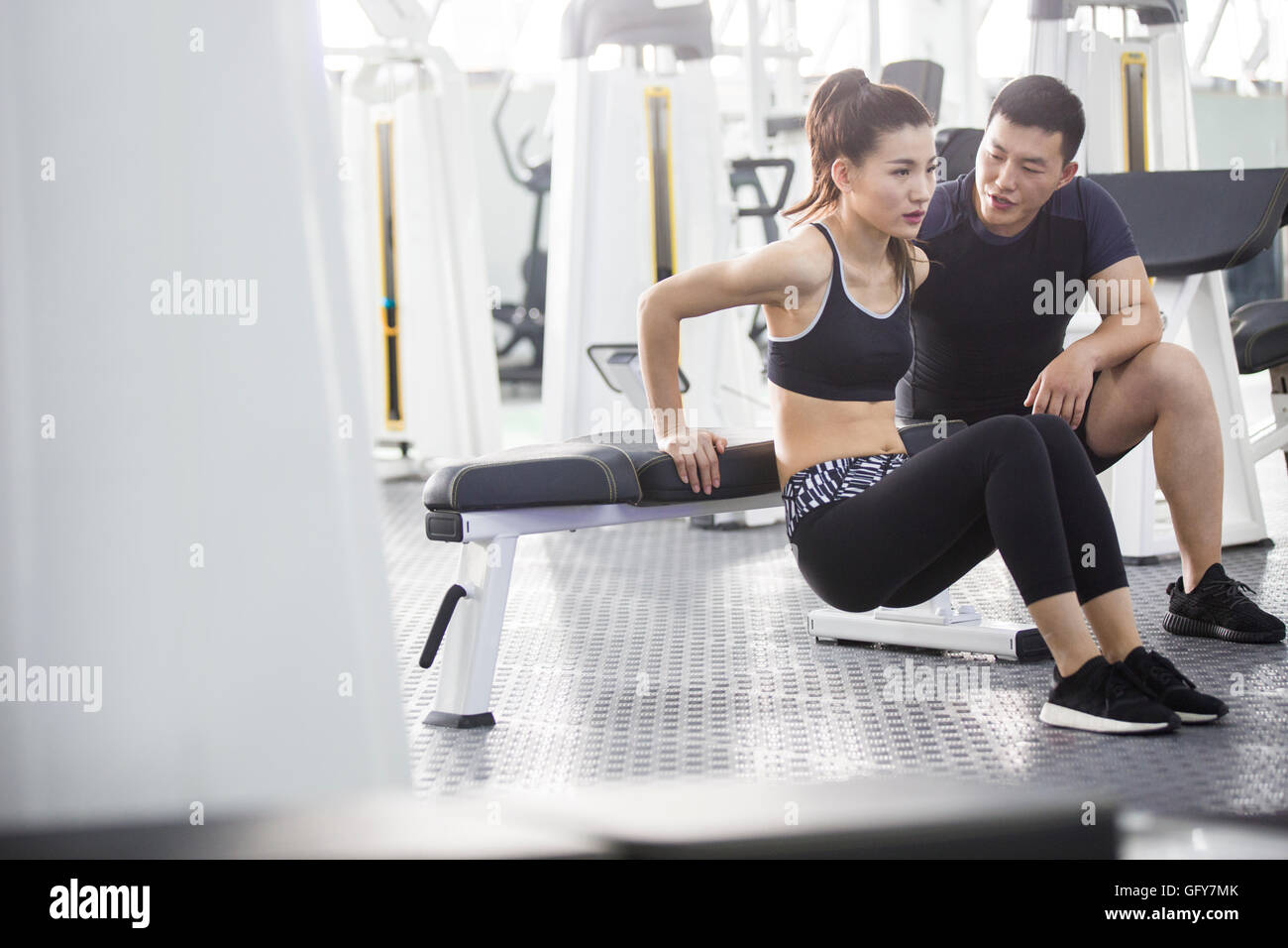 Young Chinese woman working with trainer at gym Stock Photo - Alamy