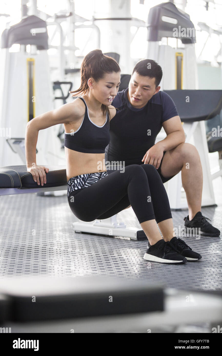 Young Chinese woman working with trainer at gym Stock Photo - Alamy