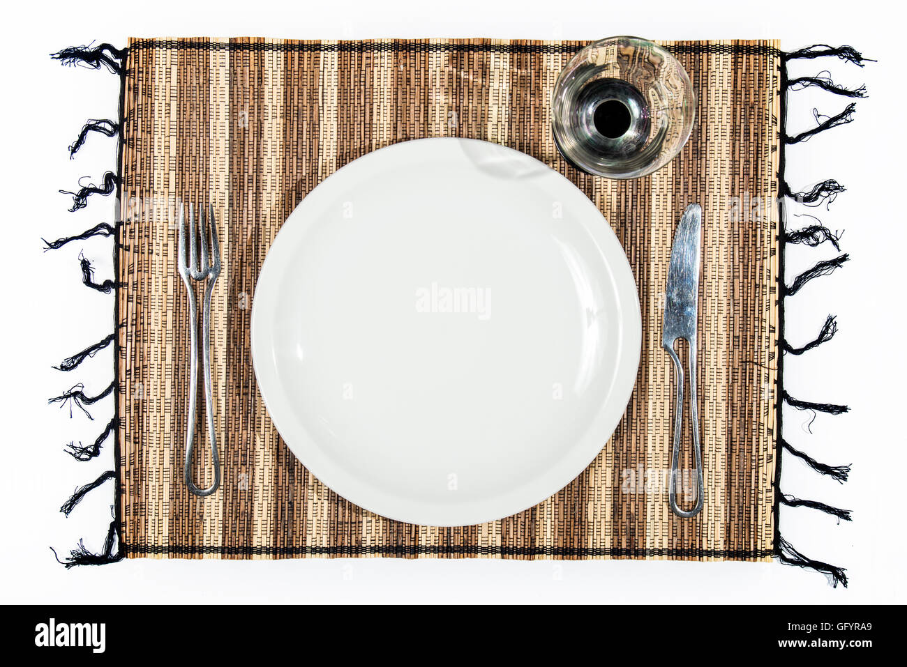 plate, cutlery and cup on a single bamboo isolated on white background