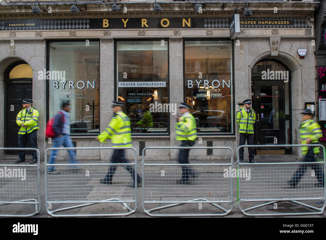 Holborn, London, UK 01 Aug 2016. Police stand guard before the Protestors arrive oustide the Holborn branch of the Byron Burger restaurant chain in response to its perceived involment in a 'sting' on illegal immigrants amongst its staff last week. Credit:  Guy Bell/Alamy Live News Stock Photo
