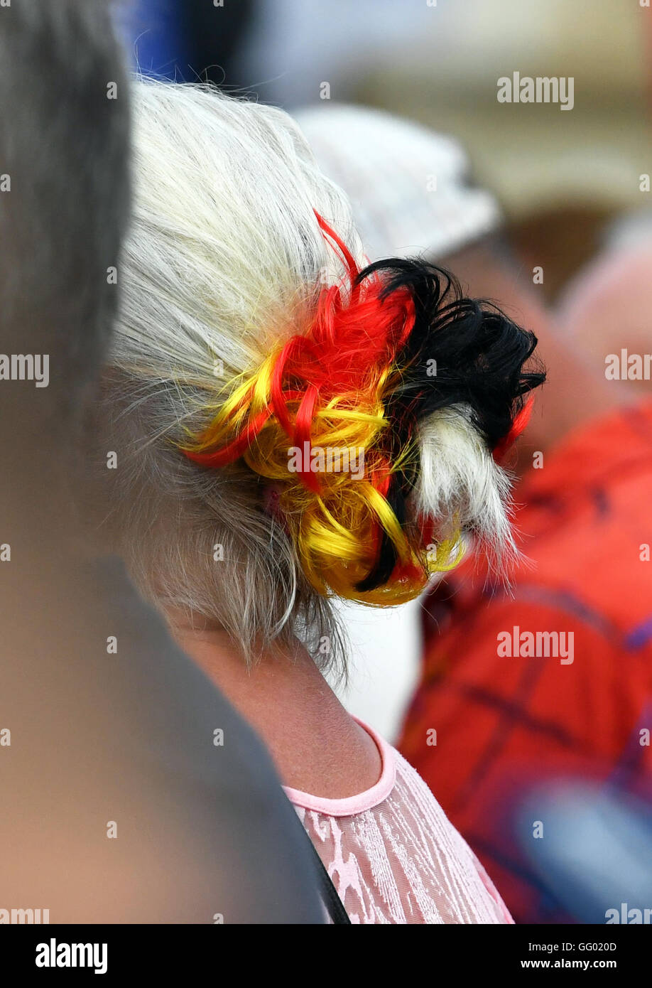 A female supporter of the anti-islam, right-wing populist political movement 'Pegida', wears a black-red-gold scrunchie during a demonstration in Dresden (Saxony), Germany, 01 August 2016. Photo: dpa-Zentralbild Stock Photo