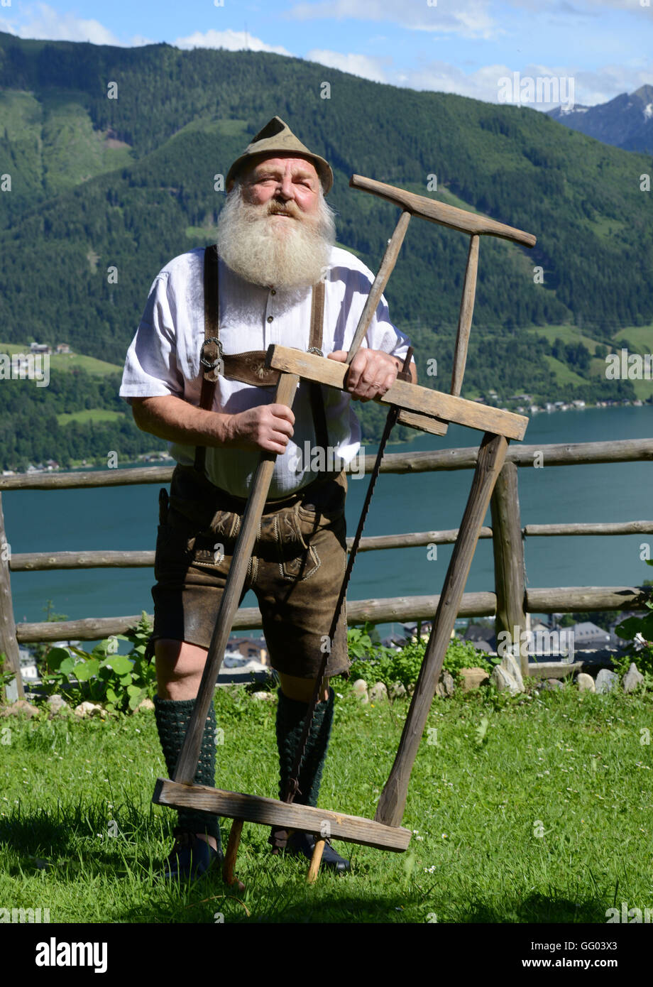 Bearded man Fritz Sendlhofer in leather pants and a traditional shirt in his garden high above the town Zell am See in Austria on 15 June 2016. With his Garibaldi beard he made it Vice European Champion, World Champion and even beard Olympia winner. On 06 August 2016, he will be at the 2nd international Austrian championship of bearded men in the course of the 34th village feast in Dorfgastein. In 2012, he was awarded for the most beautiful Garibaldi beard of the universe. Fritz Sendlhofer runs his own small sewing museum with more than 2500 sewing machines and 1000 beer mugs and he brews his Stock Photo