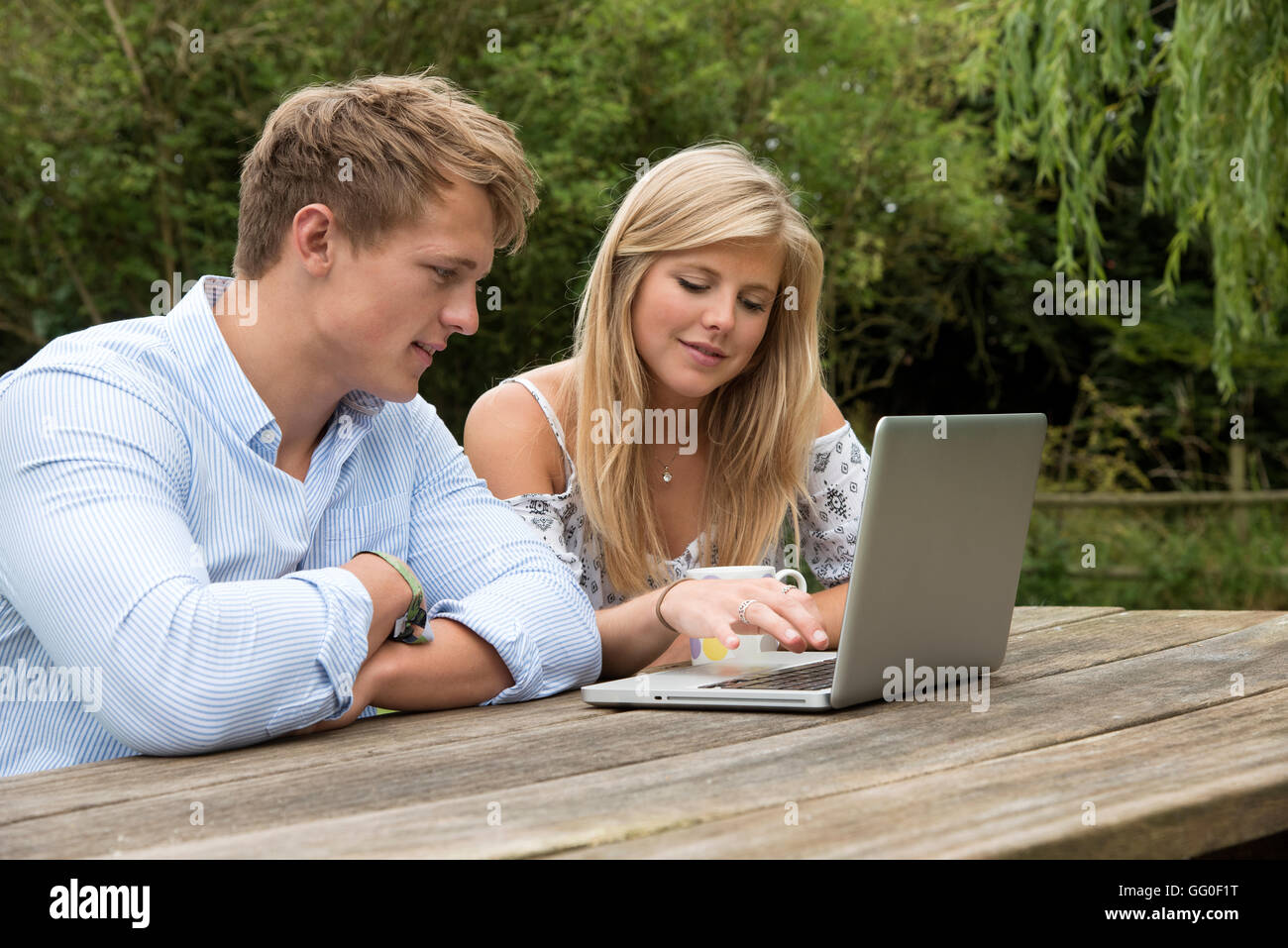 TEENAGERS USING A COMPUTER - A teenage couple using a computer on a ...