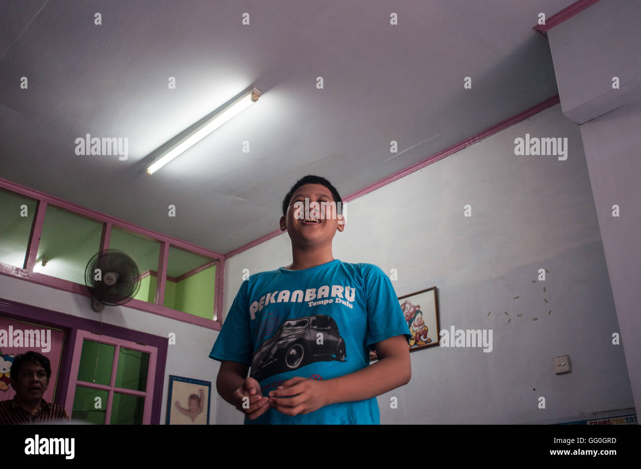 A autistic boy performs the act of prayer during a theraphy session in Makassar, Indonesia. Stock Photo