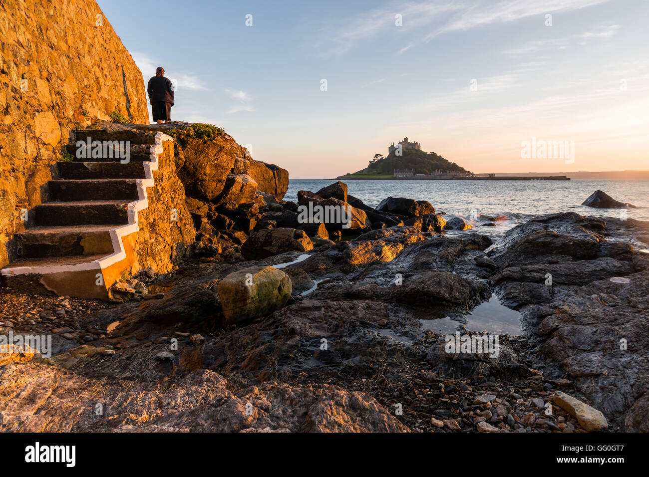 Lady stand on the shore to watch St Michael Mount Stock Photo