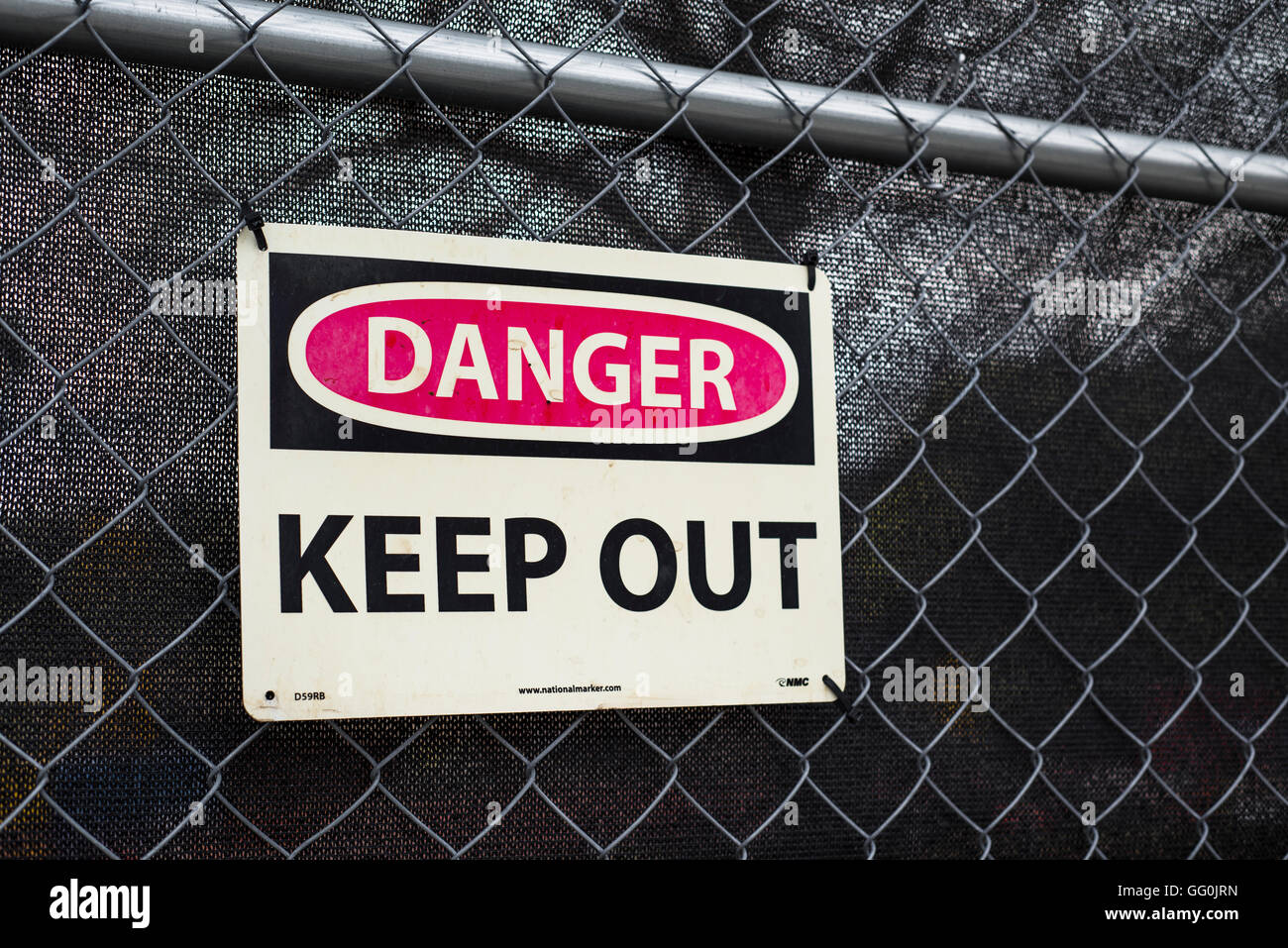 A sign sayiing 'keep out' hung on a fence at a construction site. Stock Photo