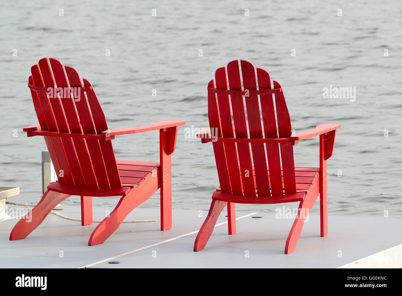 Two Red Adirondack Chairs on a Dock by the Lake Stock Photo Alamy