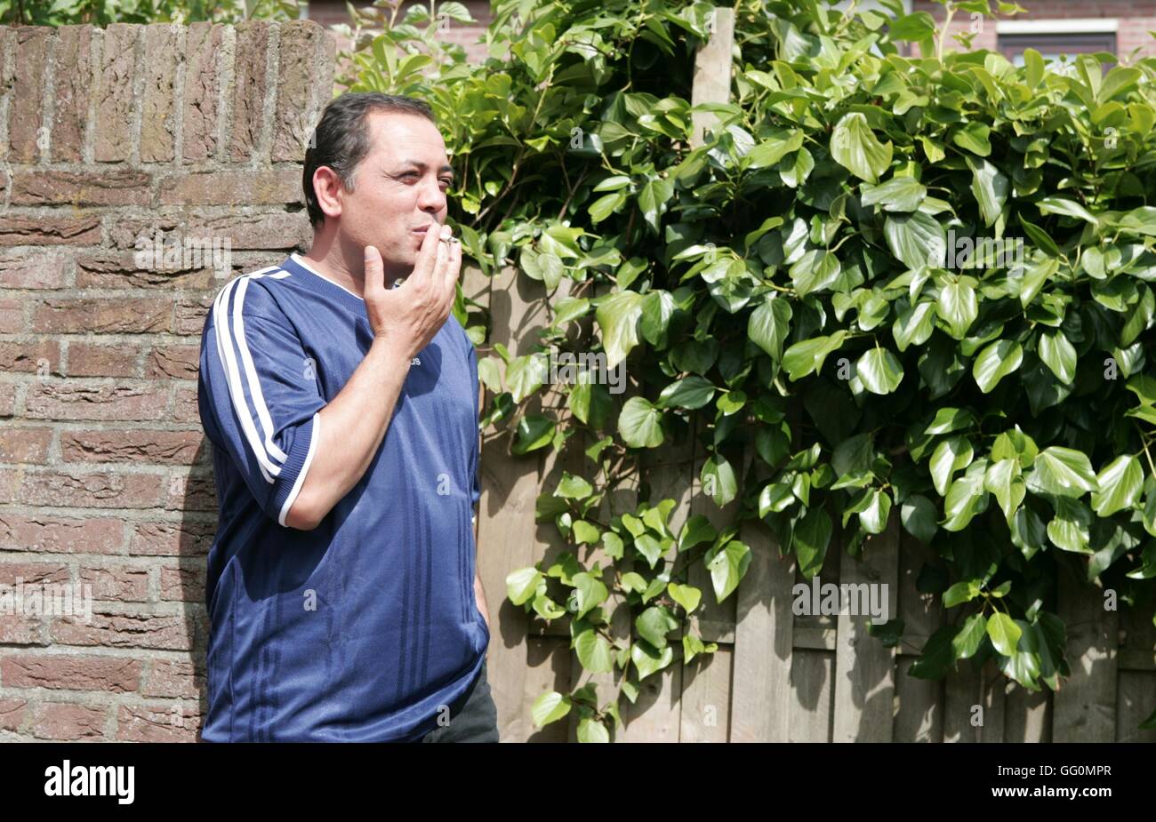 Adult man smoking a cigarette outside Stock Photo
