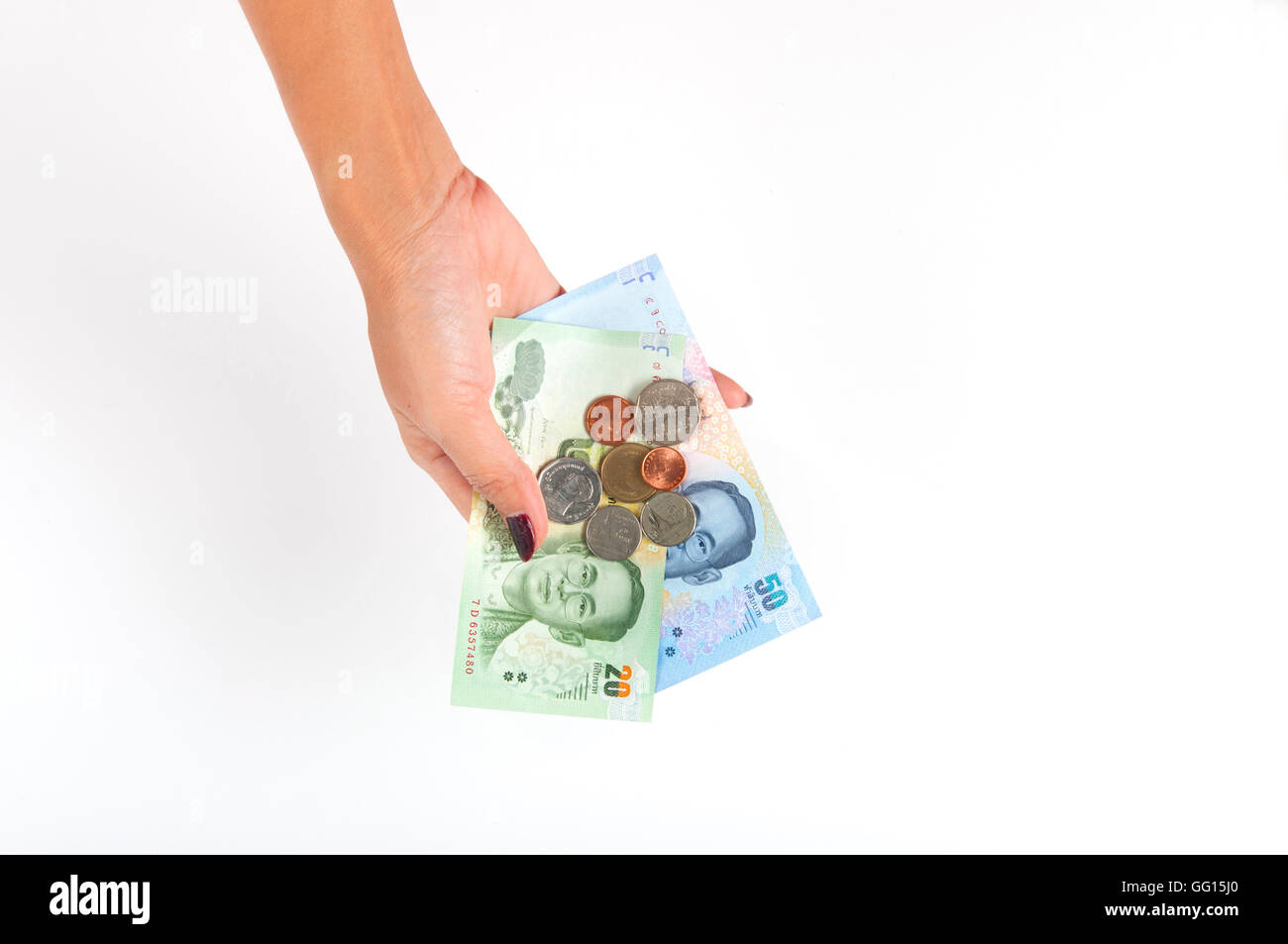 Woman hand holds Thailand currency cash with coins Stock Photo