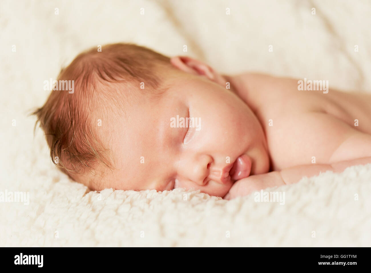 The baby, newly born, lies on the bright plaid and sleeping, handle the ...