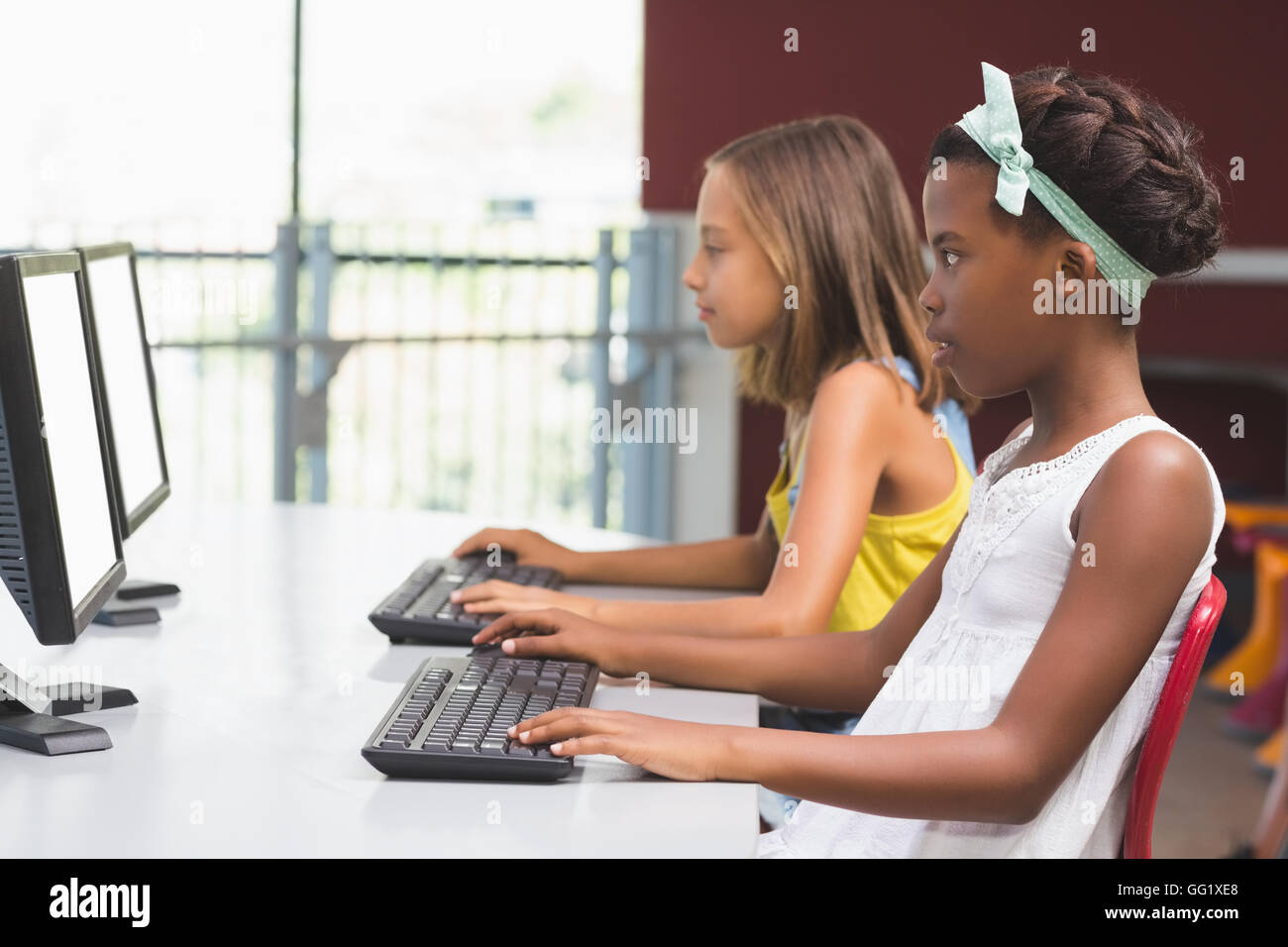 Schoolgirls using computer in classroom Stock Photo - Alamy