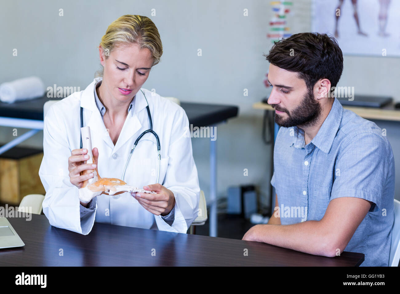 Physiotherapist showing a skeleton feet model to patient Stock Photo