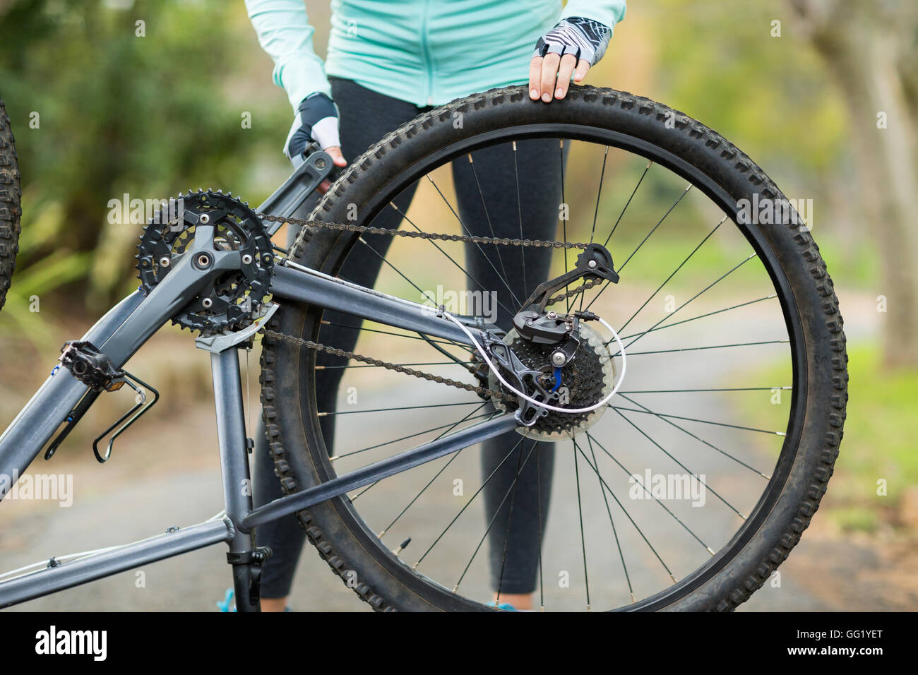 Mid section of woman repairing bicycle tyre Stock Photo
