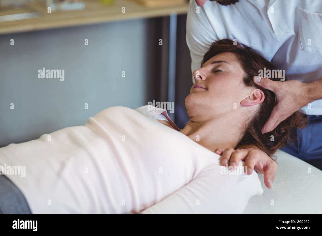 Physiotherapist giving head massage to a woman Stock Photo