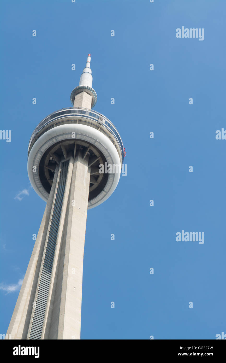 CN Tower Toronto against a blue sky with the tiny red specks of people completing the edge walk Stock Photo