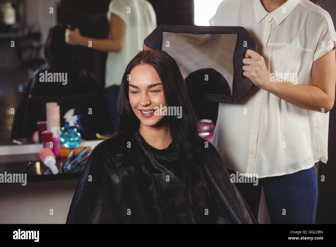 Hairdresser showing woman her haircut in mirror Stock Photo Alamy