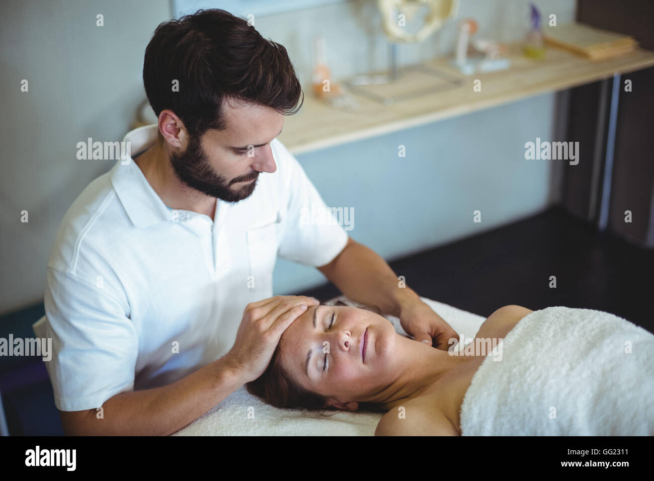 Physiotherapist giving neck massage to a woman Stock Photo