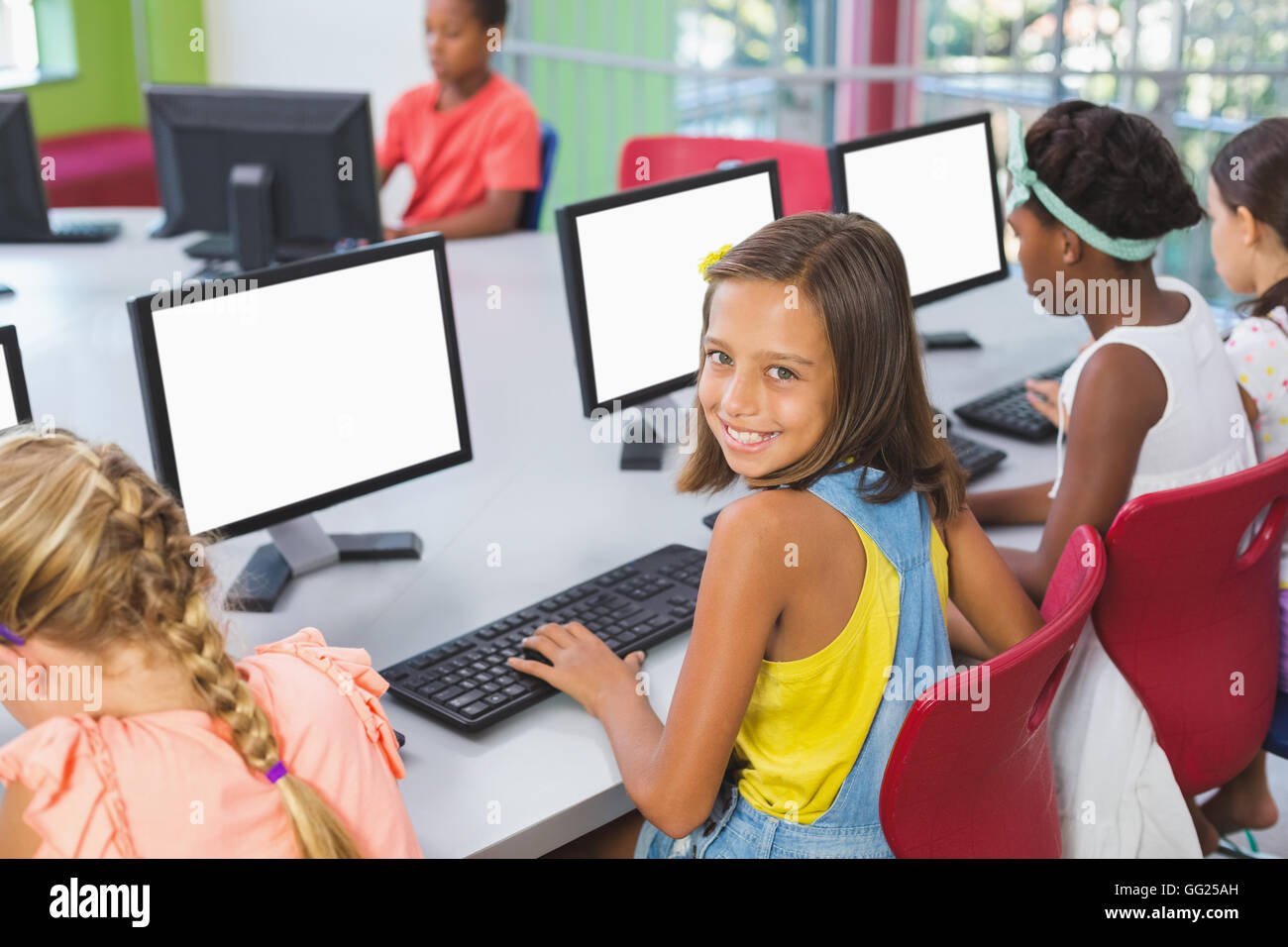 School kids using computer in classroom Stock Photo
