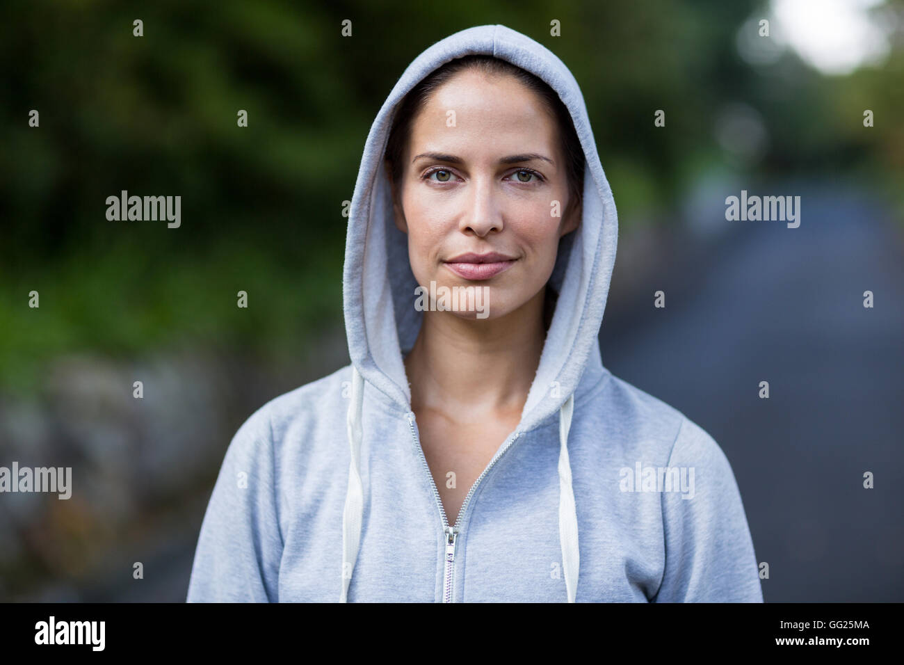 Confident woman wearing hooded sweater Stock Photo