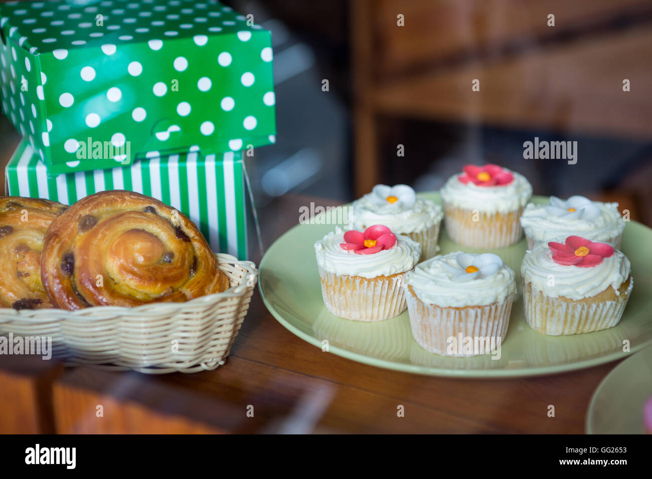 Close-up of cupcakes, desserts and boxes on display counter Stock Photo