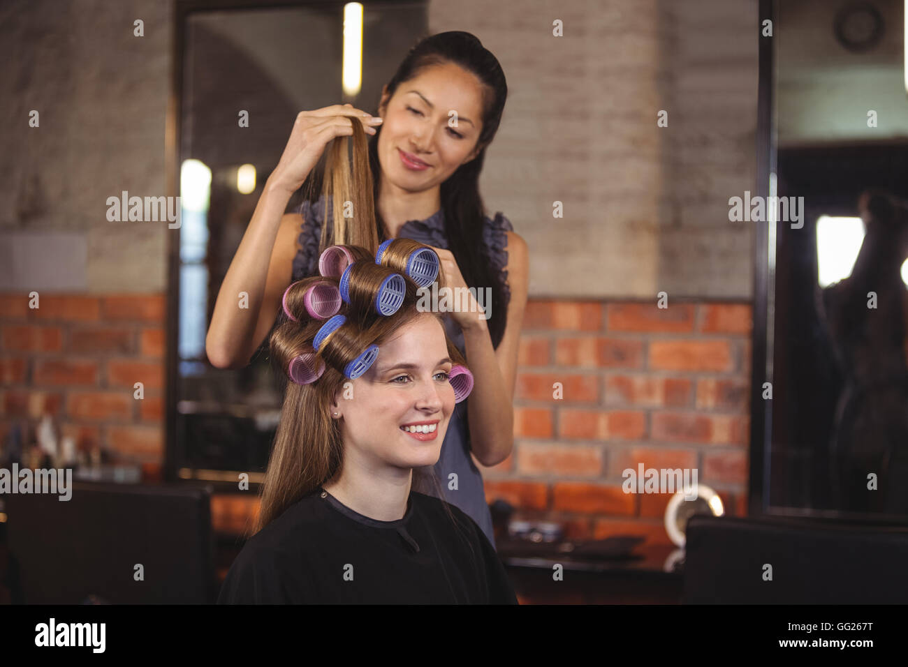 Female hairdresser styling customers hair Stock Photo