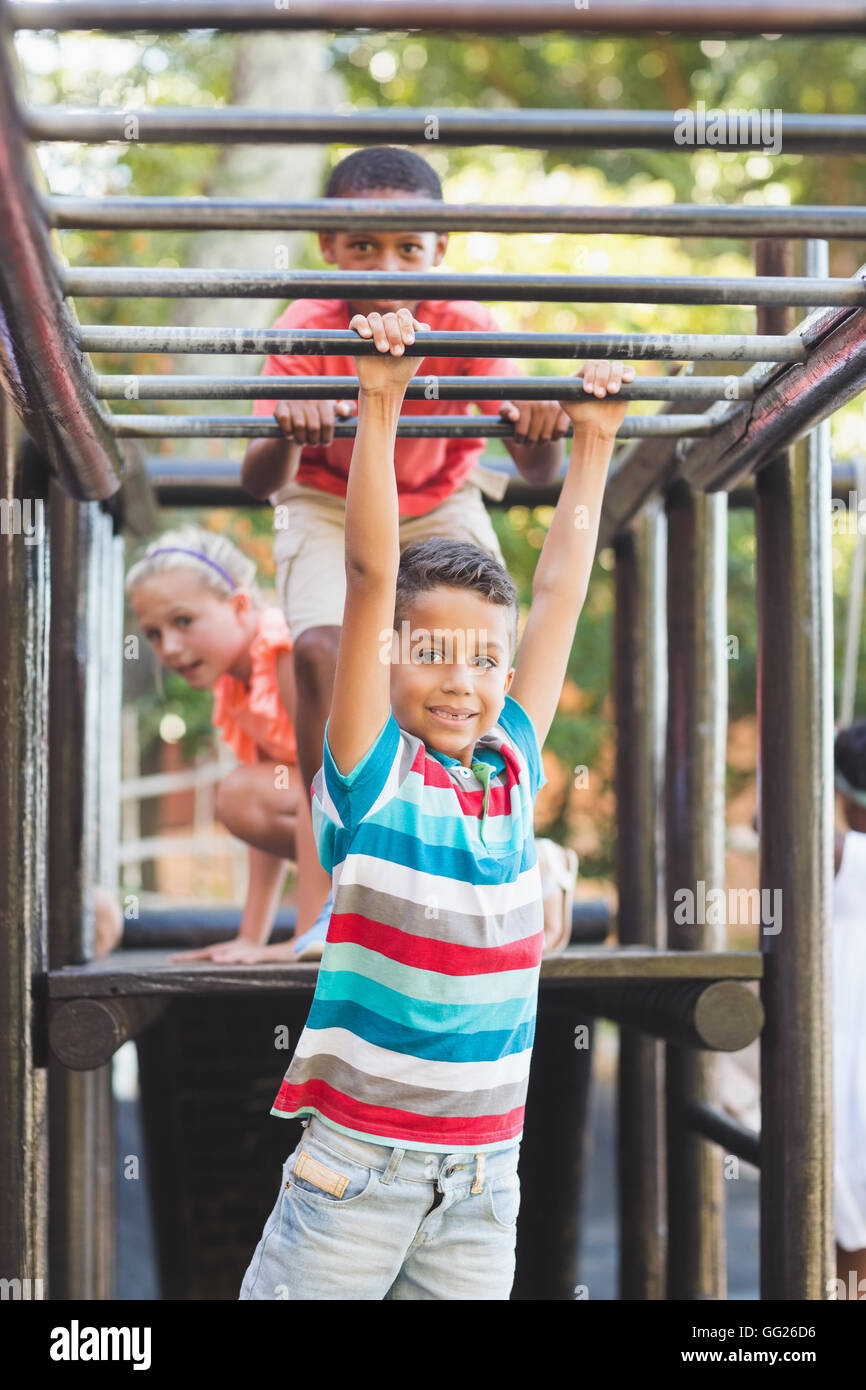 Schoolboy hanging on monkey rack Stock Photo - Alamy