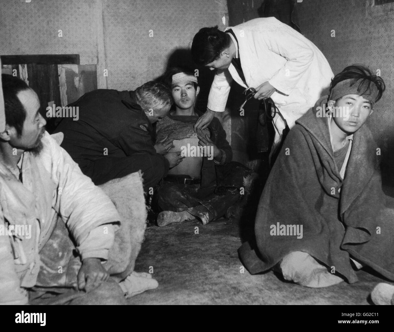 Refugees from Koje island. Doctor Henri Meyer examines a refugee suspected to have contracted typhus 1951 Korean war National Archives - Washington Stock Photo