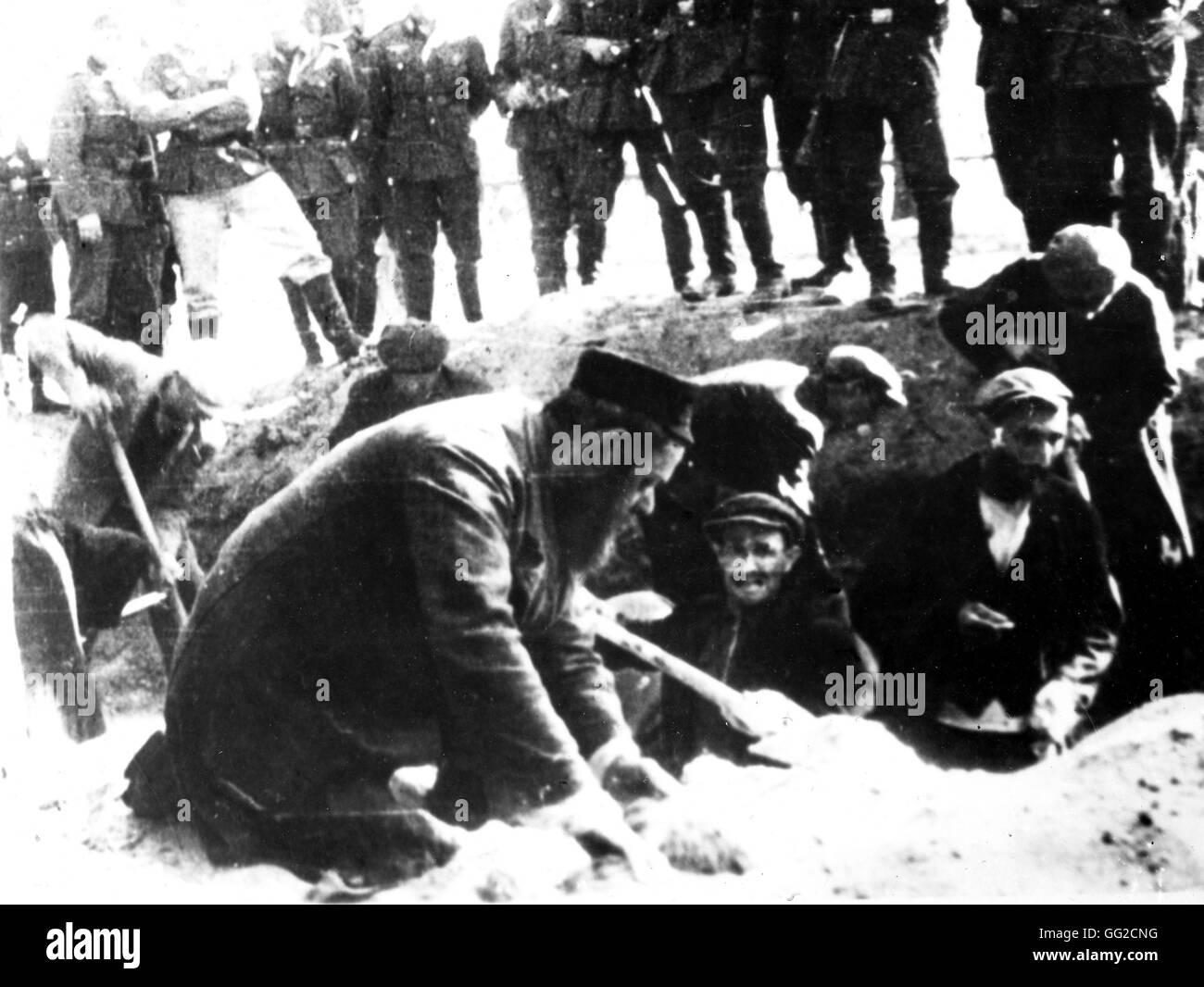 Jewish people digging their own grave, before being executed, under the German officers' eyes. Second World War World War II Paris. Bibliothèque nationale Stock Photo