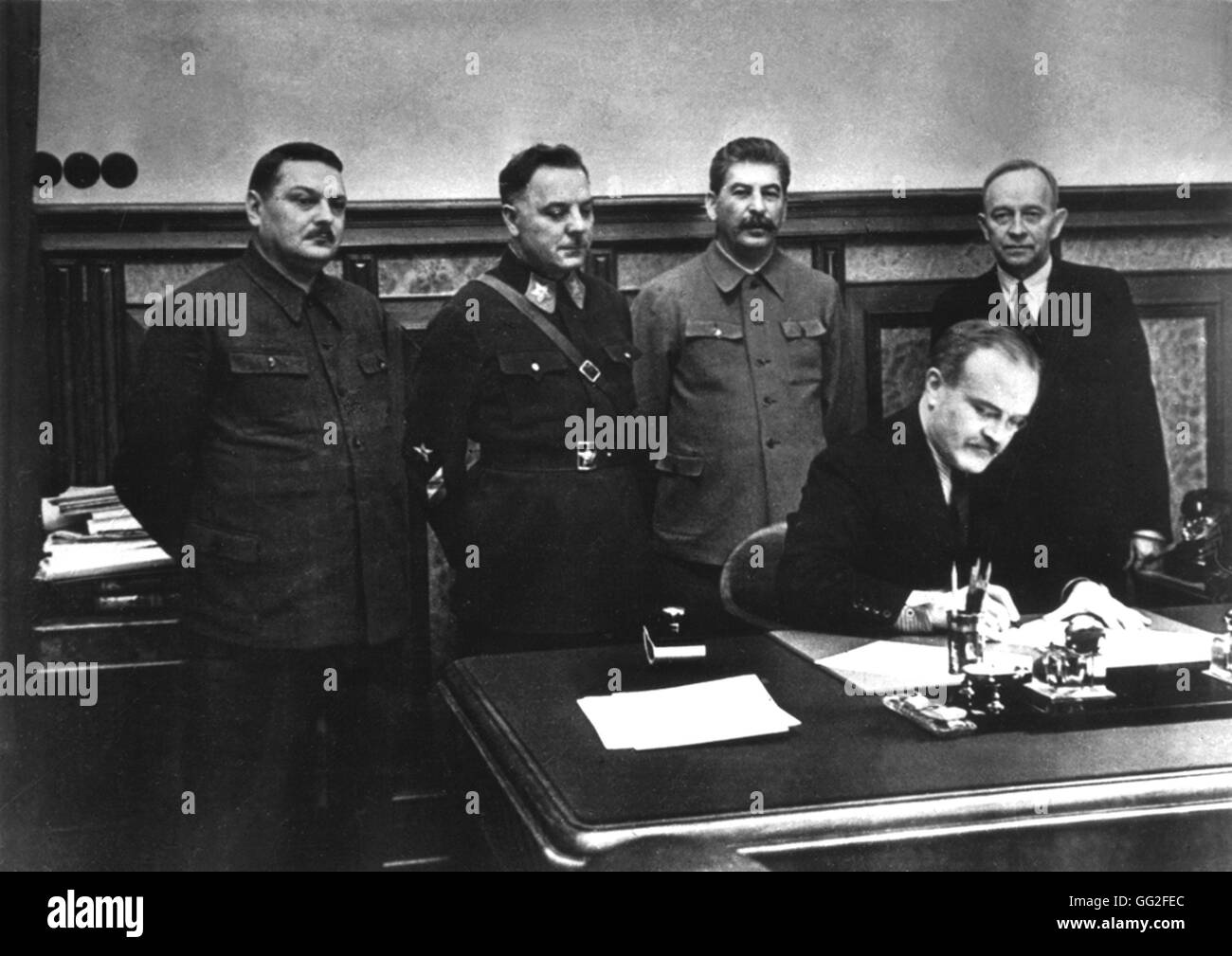 Molotov signing the mutual assistance treaty between U.S.S.R. and the Democratic Republic of Finland. From the l. to the r.: A. Zhdanov, K. Voroshilov, Stalin and O. Kunsinen) c.1950 - U.S.S.R. National archives. Washington Stock Photo
