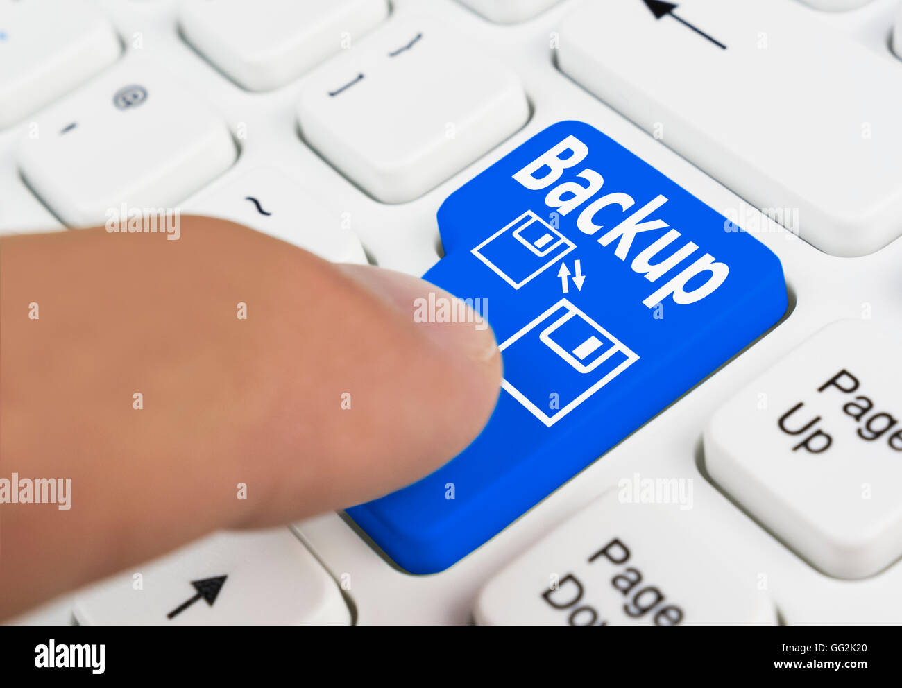 Finger pressing a computer backup button on a computer keyboard. Stock Photo