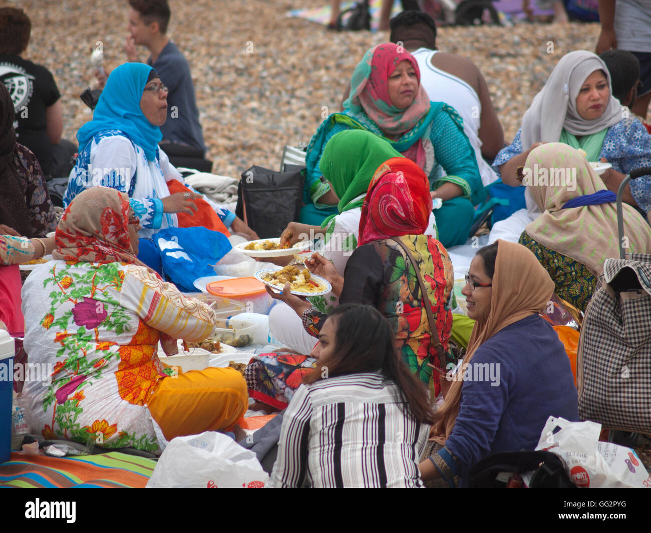 A group of Muslim women enjoy a picnic on the beach in Brighton Stock Photo