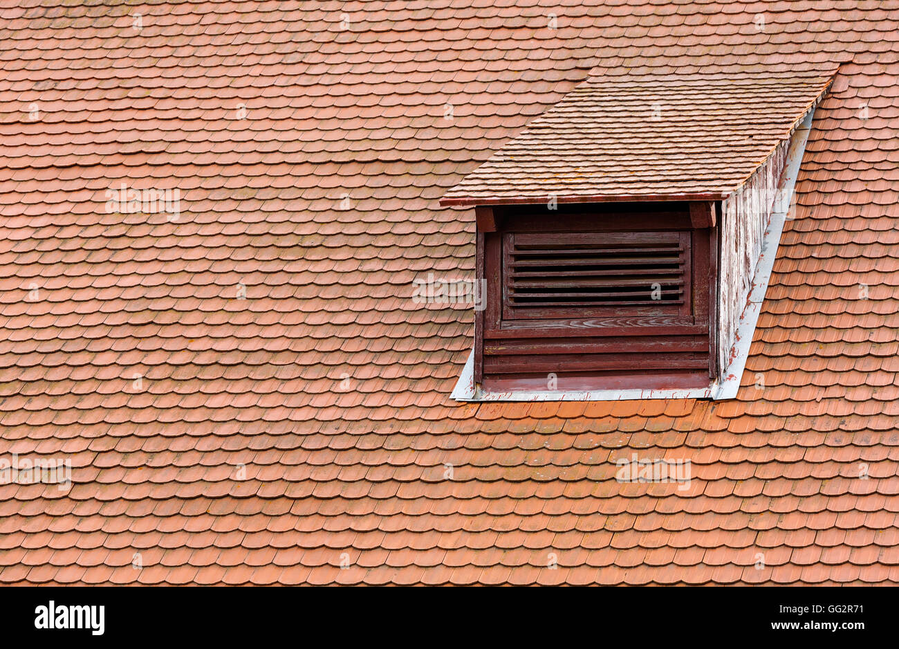 Weathered red tiled roof with dormer window Stock Photo