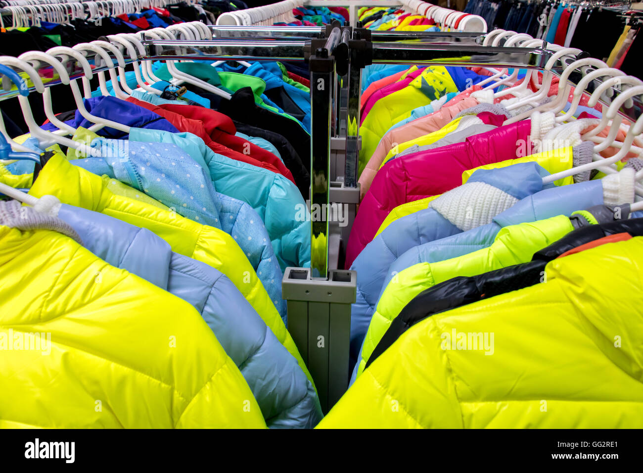 Variety of winter clothes on metal hangers. Colorful winter jackets