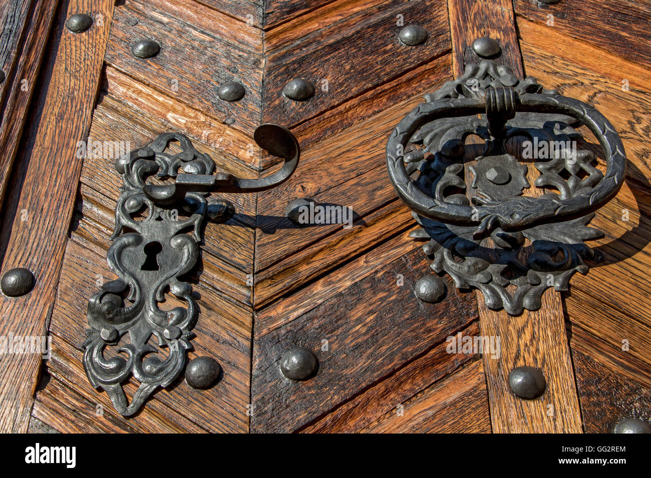 Old metal handle with knocker on a wooden door Stock Photo