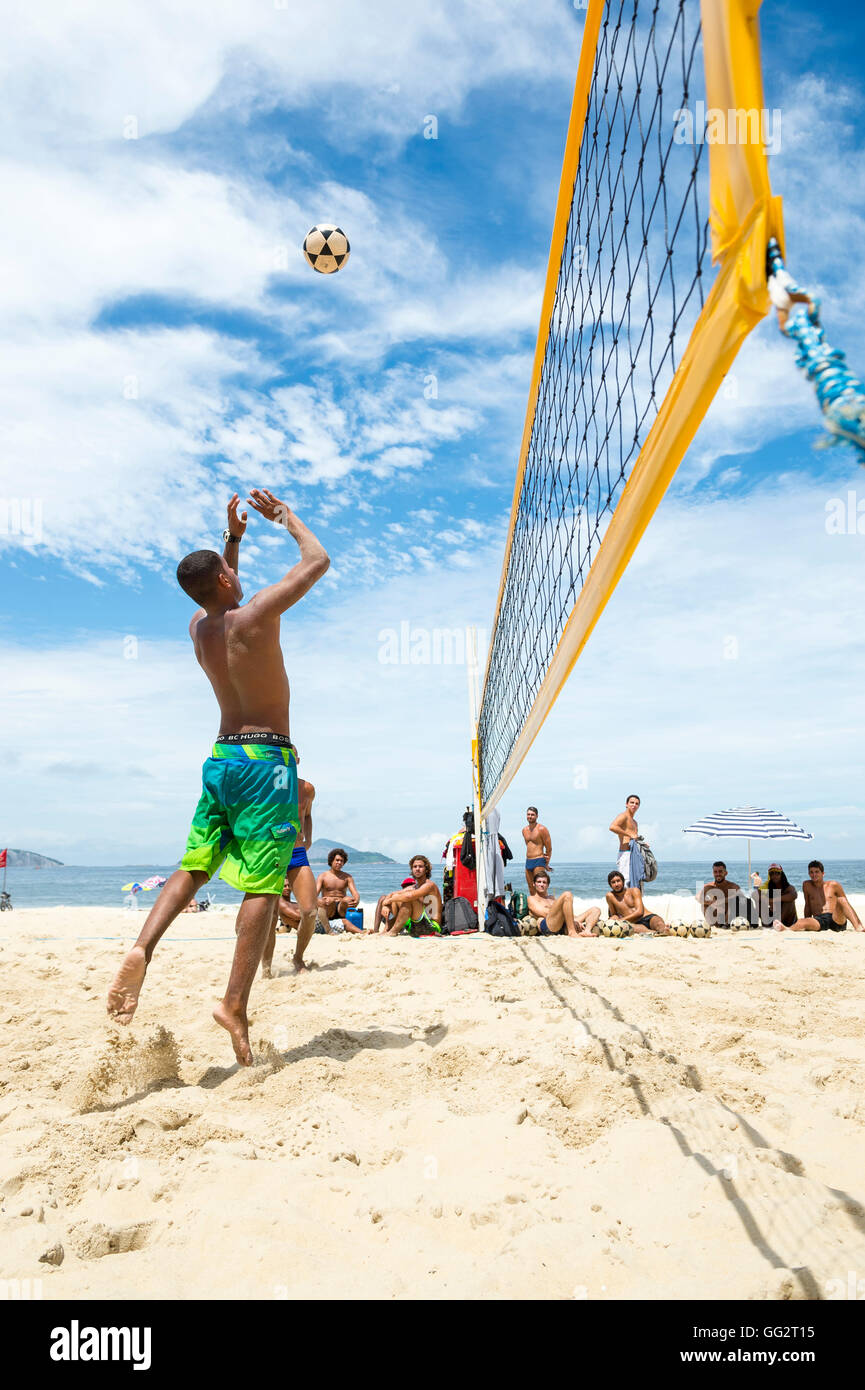 RIO DE JANEIRO - MARCH 17, 2016: Young carioca Brazilians play a game of futevolei (footvolley), a football volleyball mix. Stock Photo