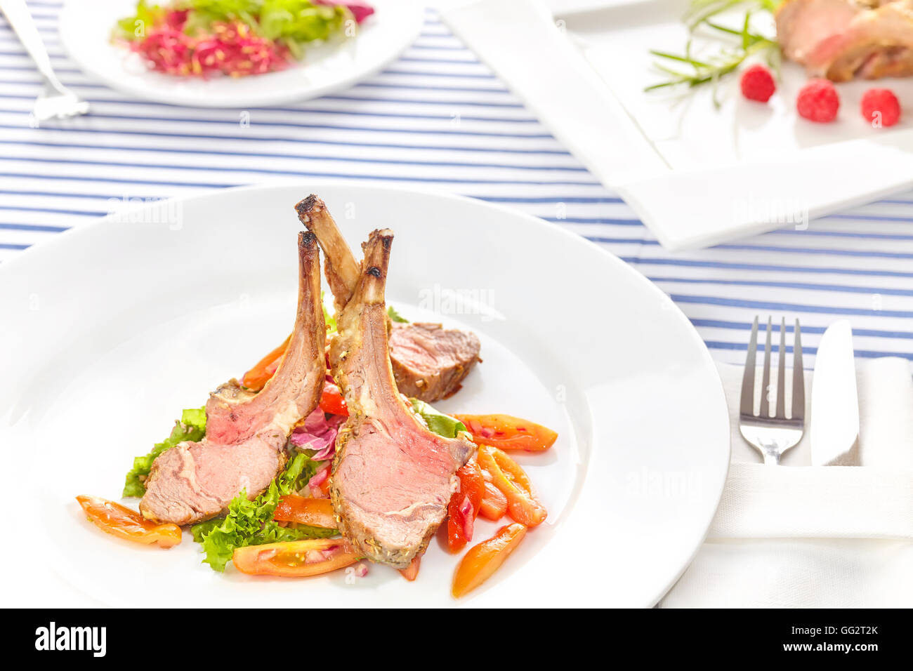 Roasted lamb rib chops with vegetables, dinner setting. Stock Photo