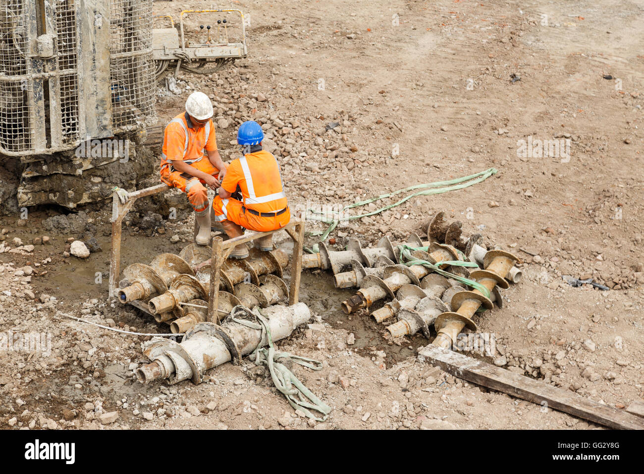 Construction workers sitting next to a pile drilling machine on a railway side site. In Ilkeston, Derbyshire, England. On 1st Au Stock Photo