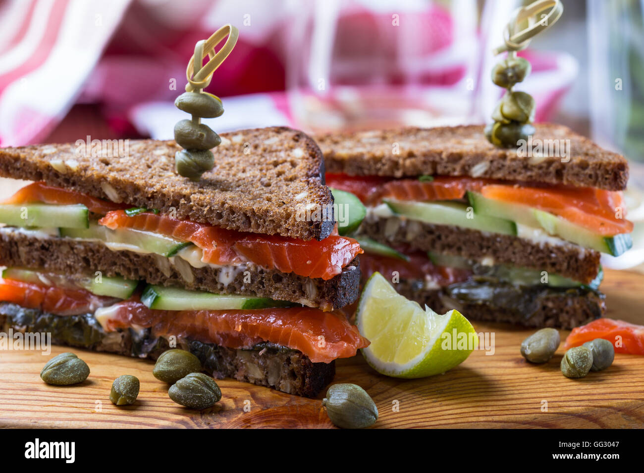 Homemade salmon club sandwich on rye bread with cucumber and sauteed