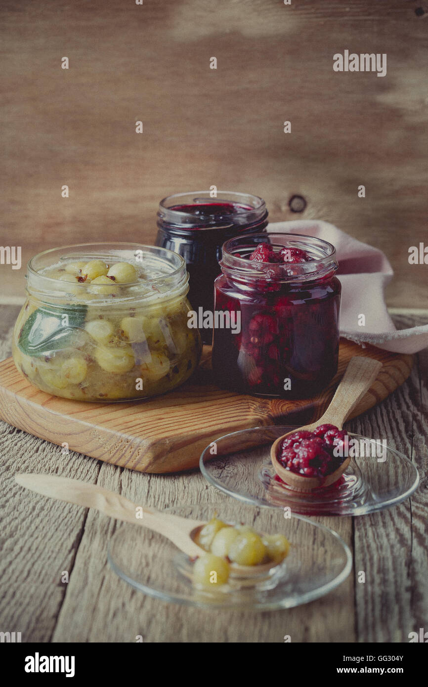 Different berry jam. Blueberry raspberry and gooseberry jam in glass