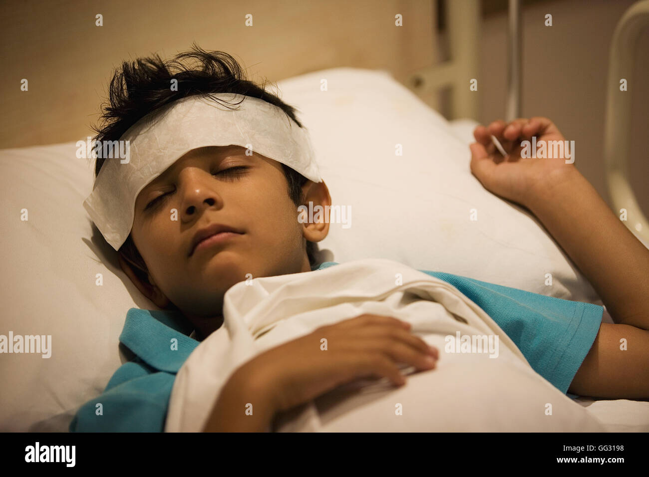 Boy sleeping with a damp cloth on his forehead Stock Photo Alamy