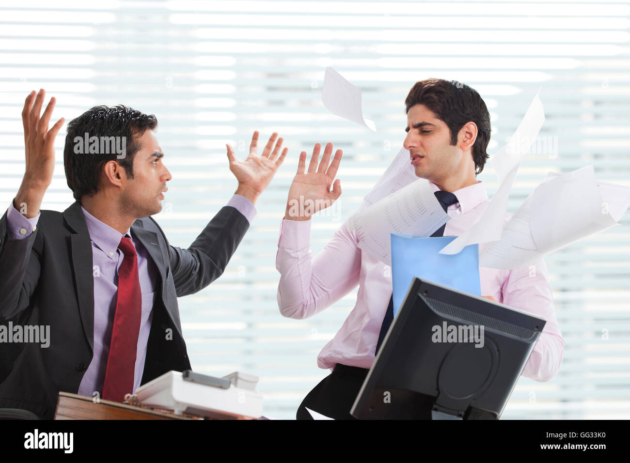 Displeased businessman throwing papers on executive Stock Photo