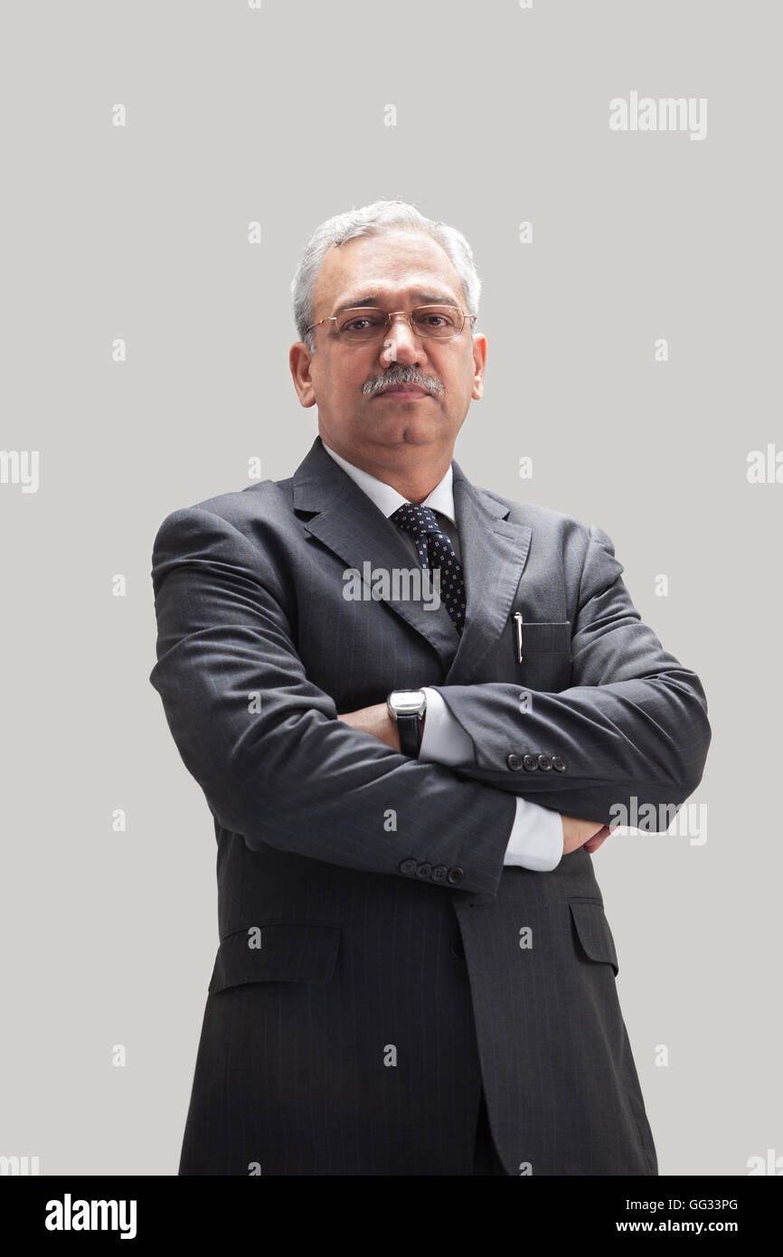 Successful mature businessman standing with arms crossed Stock Photo ...
