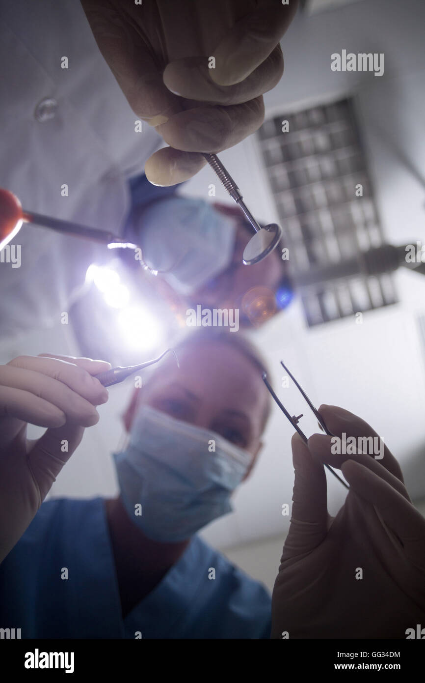 Dentist in surgical mask holding dental tools Stock Photo