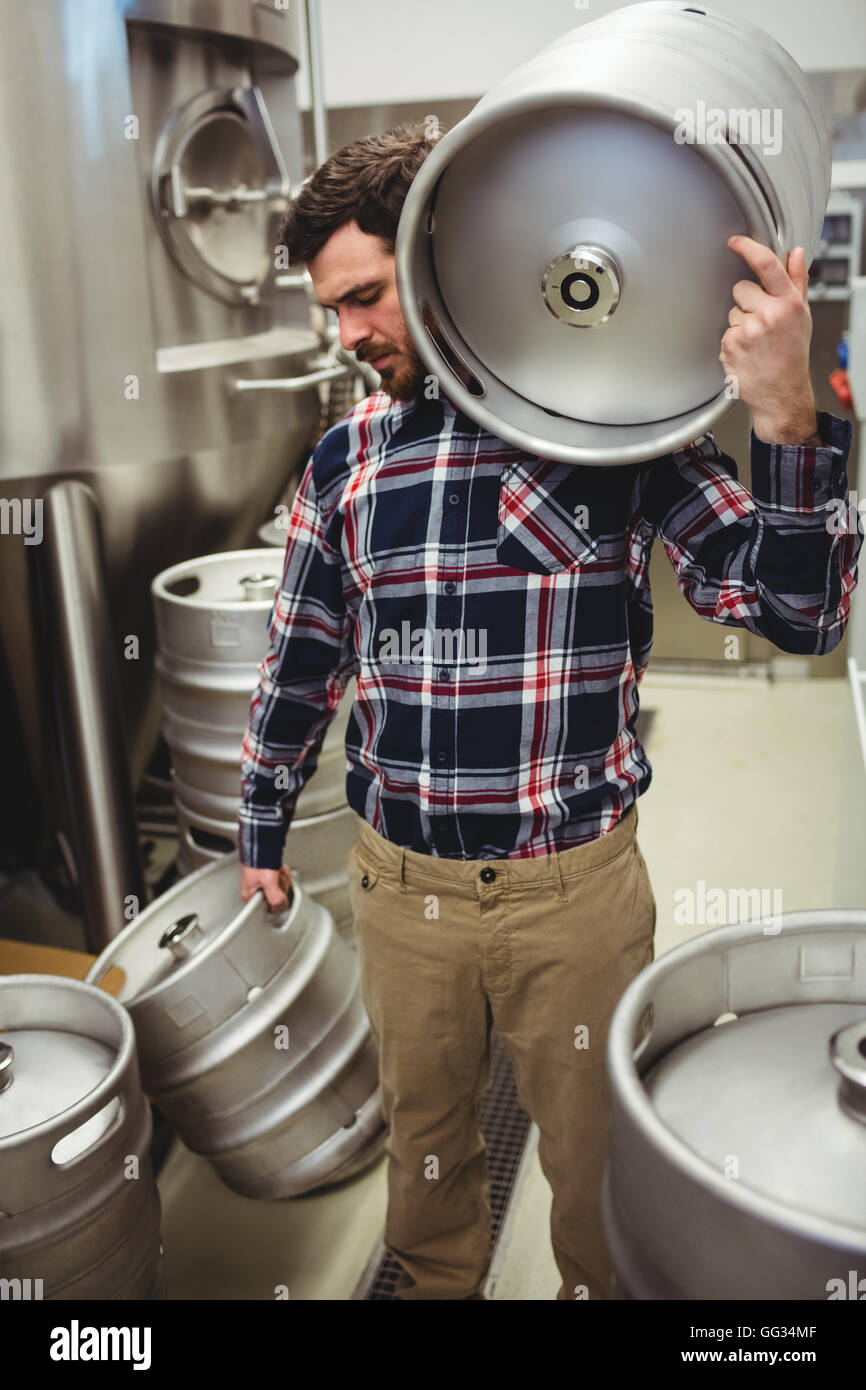 Manufacturer carrying kegs in brewery Stock Photo Alamy