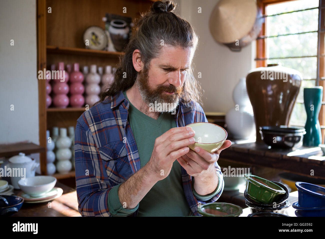 Male potter checking bowl Stock Photo - Alamy