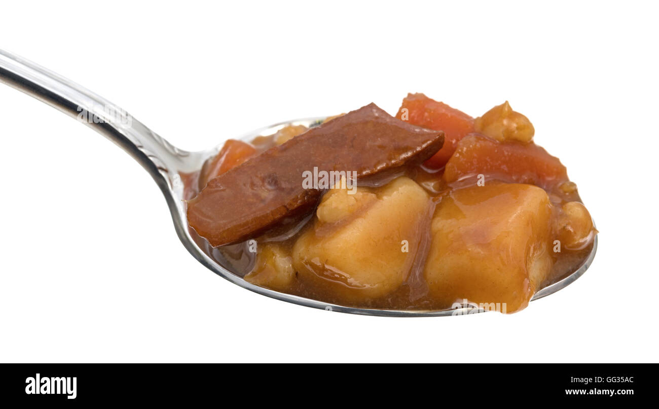 A soup spoon filled with beef stew on a white background. Stock Photo