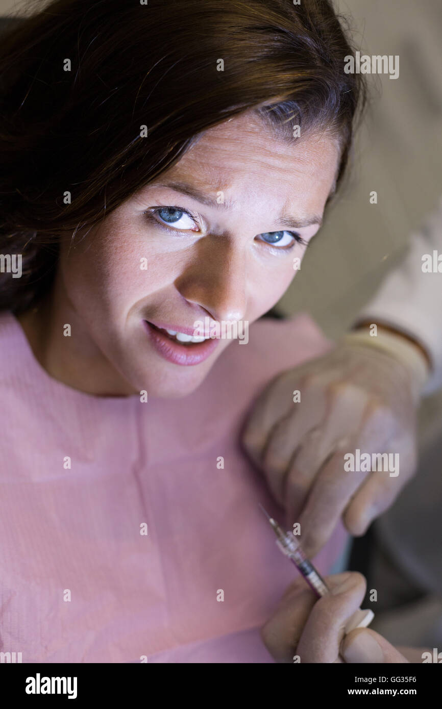 Dentist injecting female patient Stock Photo