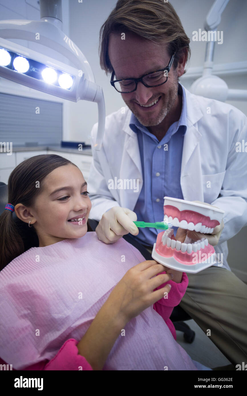 Dentist showing young patient how to brush teeth Stock Photo Alamy
