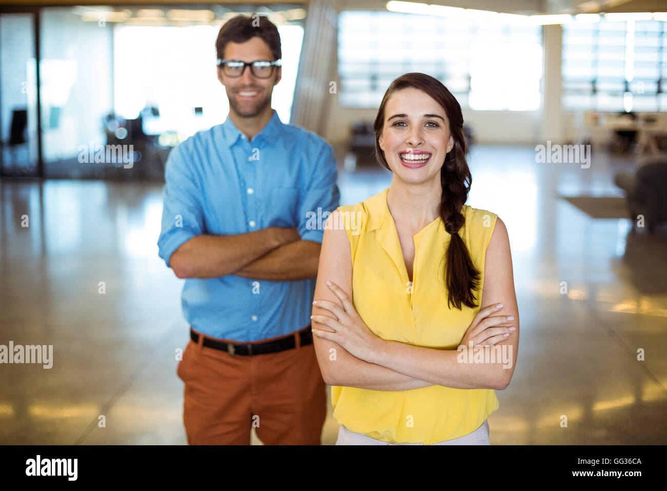 Business executive and co-worker standing with arms crossed Stock Photo